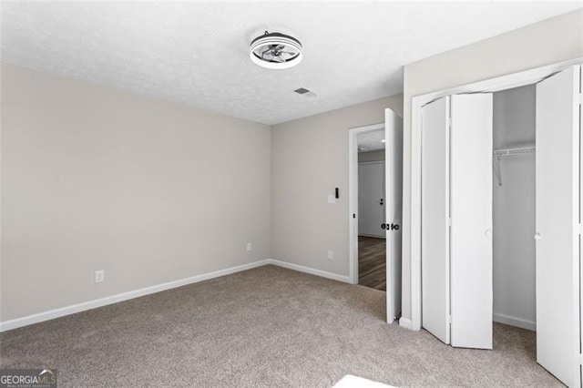 unfurnished bedroom featuring a closet, light colored carpet, and baseboards