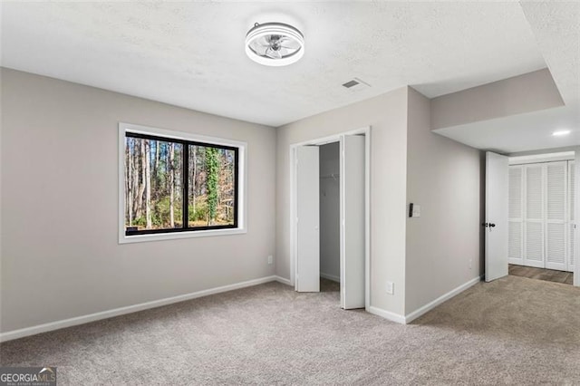 unfurnished bedroom with baseboards, visible vents, and carpet floors