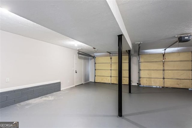 garage with a garage door opener and baseboards