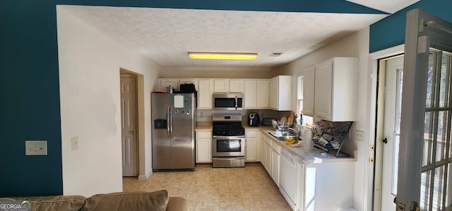 194 Goldleaf Dr, Hampton, GA 30228 - kitchen with light countertops, white cabinets, a wealth of natural light, and stainless steel appliances