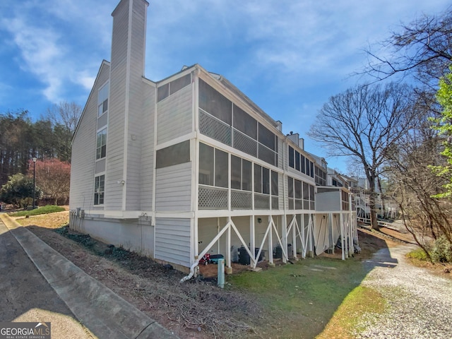 3705 Tradewinds Dr, Cumming, GA 30041 - back of house featuring a chimney and a sunroom