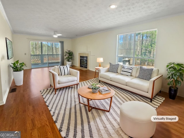 3705 Tradewinds Dr, Cumming, GA 30041 - living room featuring visible vents, a textured ceiling, wood finished floors, and a fireplace