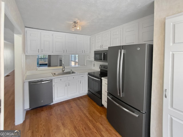 3705 Tradewinds Dr, Cumming, GA 30041 - kitchen featuring a sink, stainless steel appliances, light countertops, white cabinets, and dark wood-type flooring