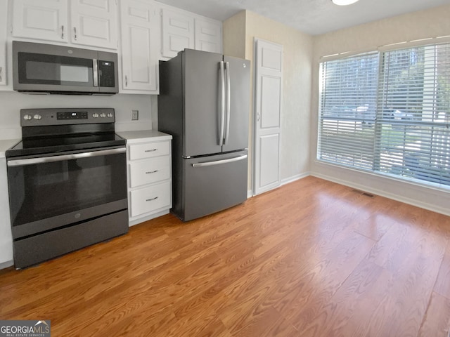 3705 Tradewinds Dr, Cumming, GA 30041 - kitchen featuring light wood finished floors, appliances with stainless steel finishes, white cabinetry, and light countertops