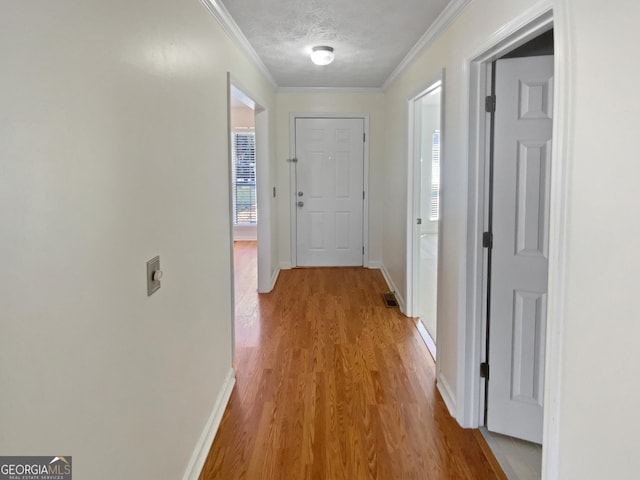 3705 Tradewinds Dr, Cumming, GA 30041 - hallway with visible vents, a textured ceiling, light wood-style floors, crown molding, and baseboards