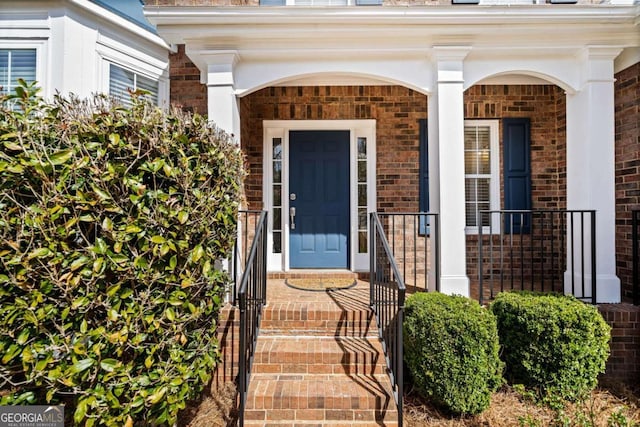 entrance to property featuring brick siding