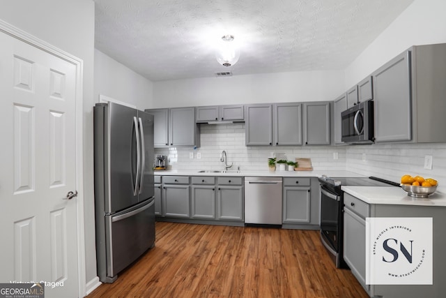 1579 Eastern Sunrise Ln, Decatur, GA 30034 - kitchen with a sink, decorative backsplash, appliances with stainless steel finishes, and gray cabinetry
