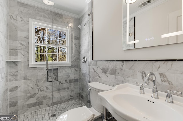 bathroom with toilet, crown molding, visible vents, and tile walls