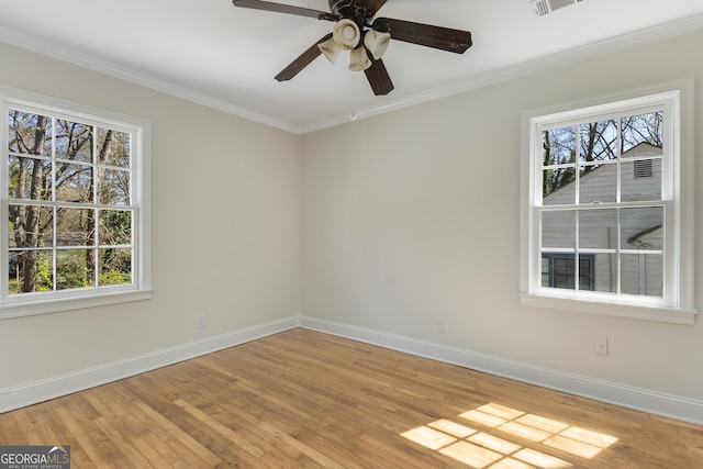unfurnished room featuring baseboards, wood finished floors, and a healthy amount of sunlight