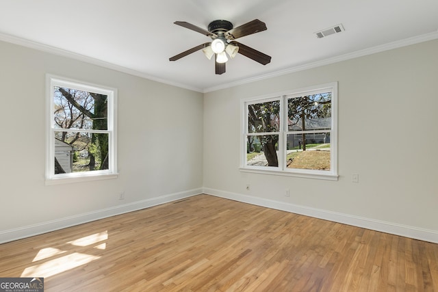 spare room with ornamental molding, visible vents, light wood finished floors, and plenty of natural light