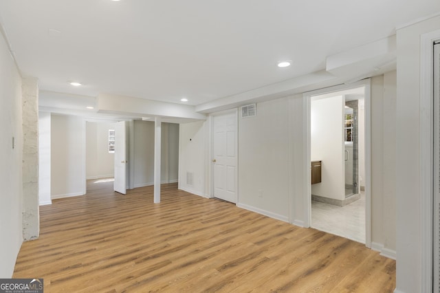 finished basement with recessed lighting, visible vents, baseboards, and light wood-style flooring