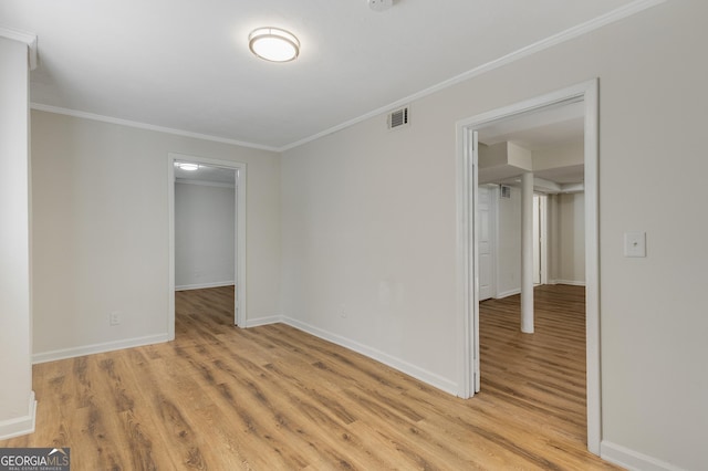 unfurnished bedroom featuring light wood finished floors, baseboards, ornamental molding, and visible vents