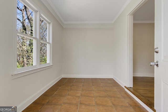 empty room with a wealth of natural light, baseboards, and crown molding