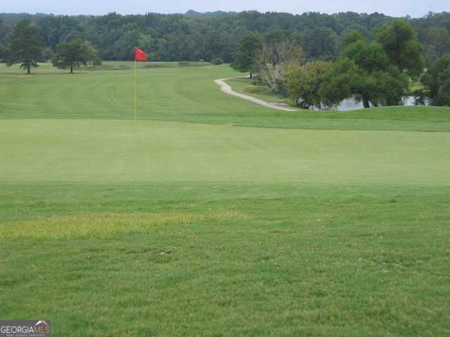 surrounding community featuring view of golf course and a lawn
