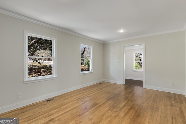 spare room with ornamental molding, visible vents, and plenty of natural light