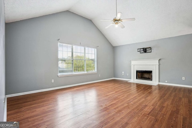 unfurnished living room with a fireplace with flush hearth, a textured ceiling, wood finished floors, baseboards, and ceiling fan