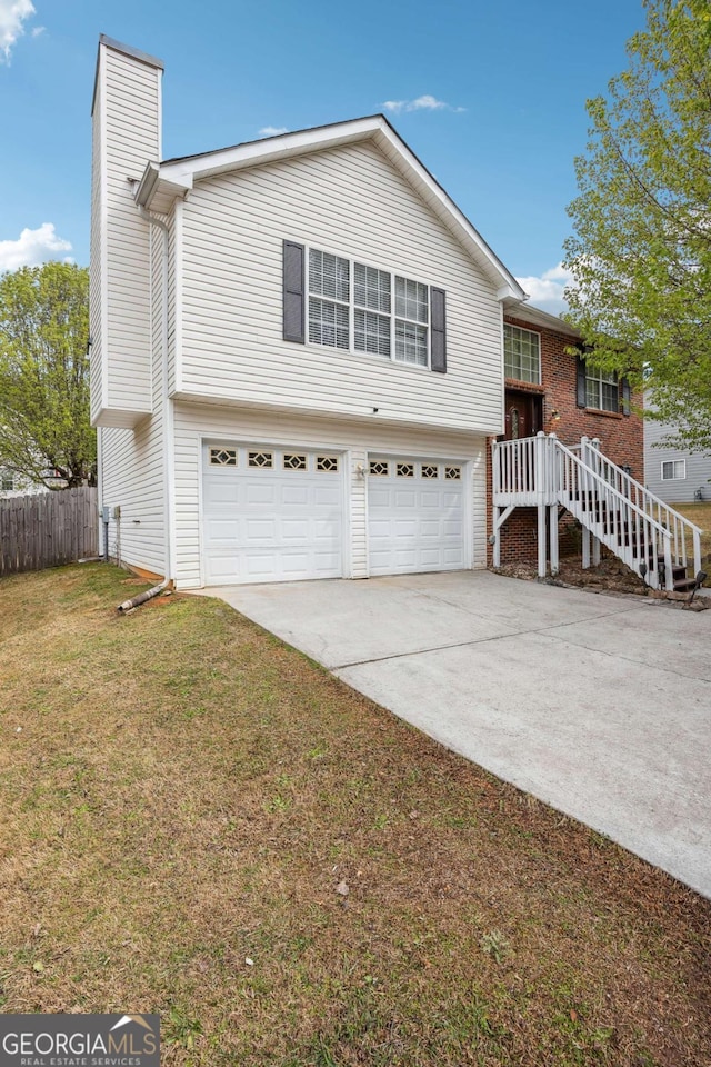 view of front of house featuring a front lawn, fence, a chimney, driveway, and an attached garage