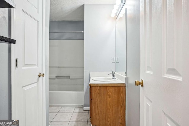 full bathroom featuring a textured ceiling, vanity, and tile patterned flooring