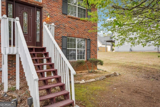 entrance to property with a yard and brick siding
