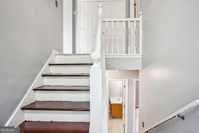 stairs with baseboards and tile patterned flooring