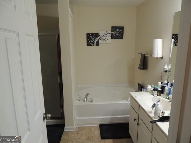 full bathroom featuring a shower stall, a bath, and vanity