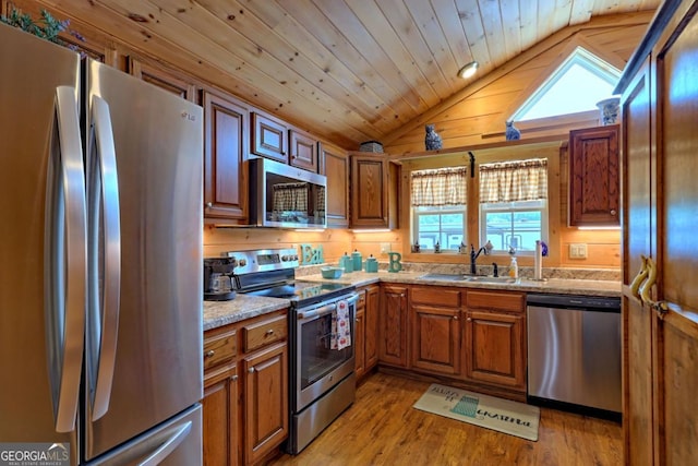 656 River Vista Dr, Dillard, GA 30537 - kitchen featuring stainless steel appliances, vaulted ceiling, brown cabinetry, and light wood-style floors