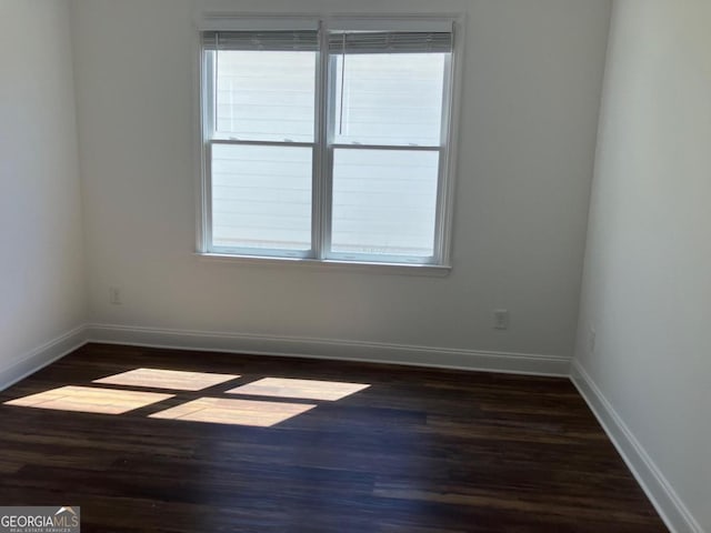 5099 Noble Village Way, Lilburn, GA 30047 - unfurnished room with baseboards and dark wood-type flooring
