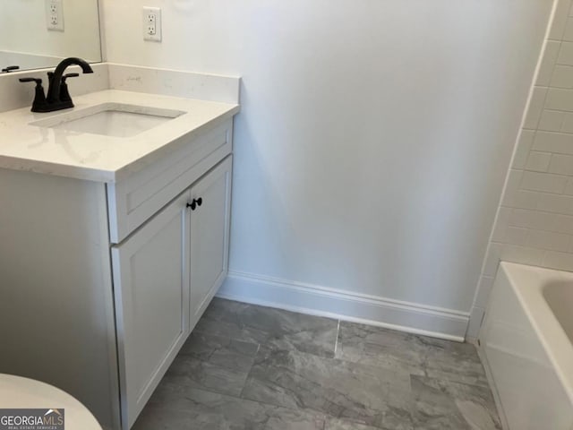 5099 Noble Village Way, Lilburn, GA 30047 - full bath with a tub, baseboards, marble finish floor, and vanity