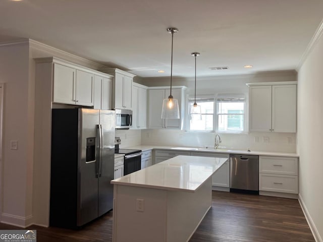 5099 Noble Village Way, Lilburn, GA 30047 - kitchen with visible vents, a kitchen island, backsplash, stainless steel appliances, and crown molding