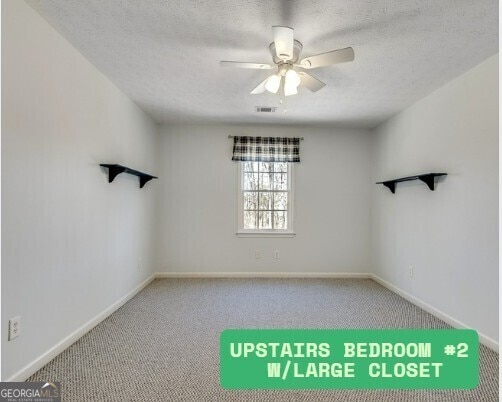 3550 Gravitt Rd, Cumming, GA 30040 - empty room with carpet flooring, ceiling fan, baseboards, and a textured ceiling