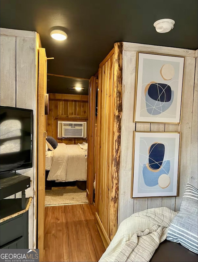 hallway with cooling unit, wooden walls, and wood finished floors