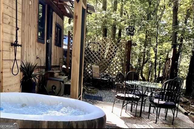 view of patio with outdoor dining space and a hot tub