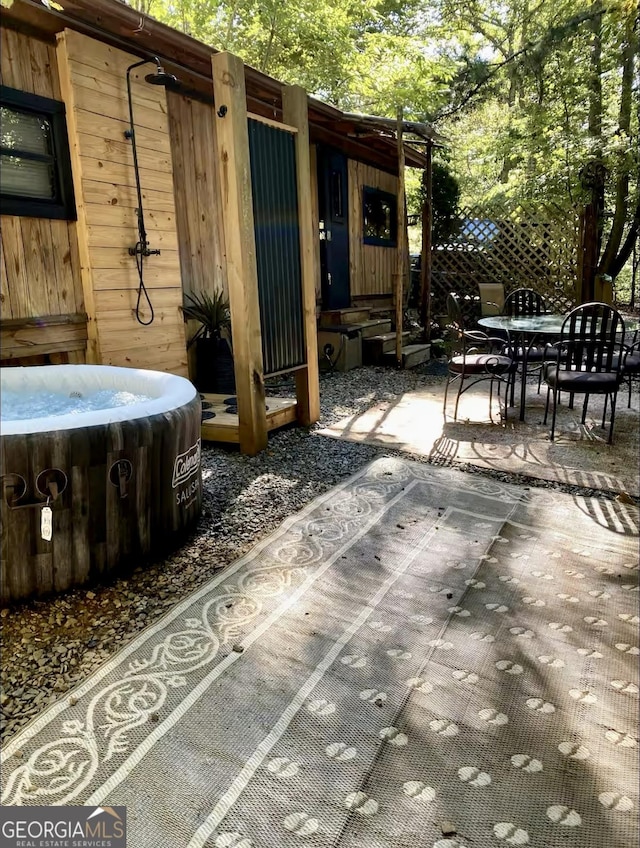 view of patio / terrace featuring outdoor dining space, central AC unit, and a hot tub