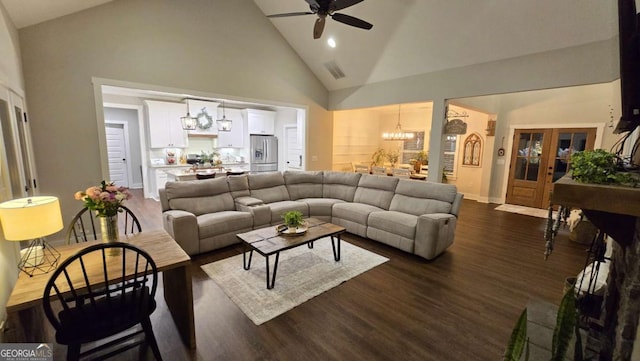 living area with visible vents, baseboards, high vaulted ceiling, dark wood-style flooring, and ceiling fan with notable chandelier