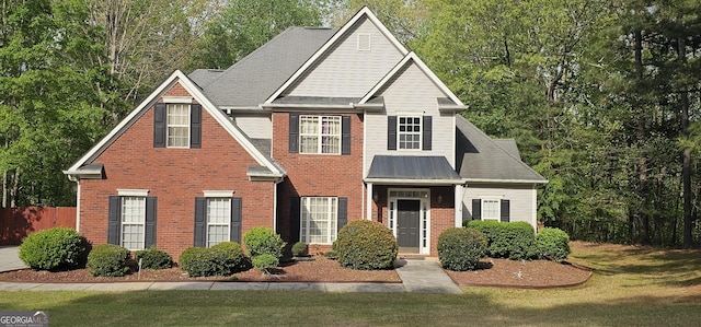 view of front of house featuring fence, a front lawn, and brick siding