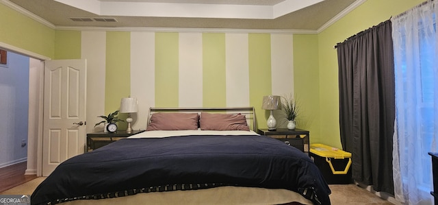 bedroom with visible vents, crown molding, and a raised ceiling