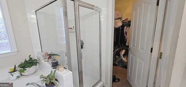 bathroom with a shower stall, a spacious closet, and a garden tub