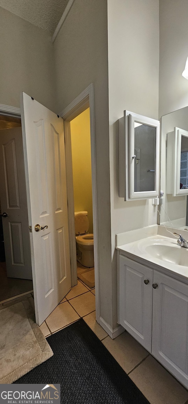 bathroom featuring toilet, tile patterned floors, and vanity