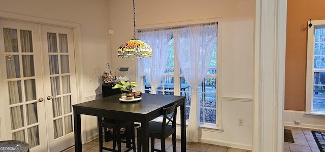 dining space featuring french doors, baseboards, and tile patterned flooring