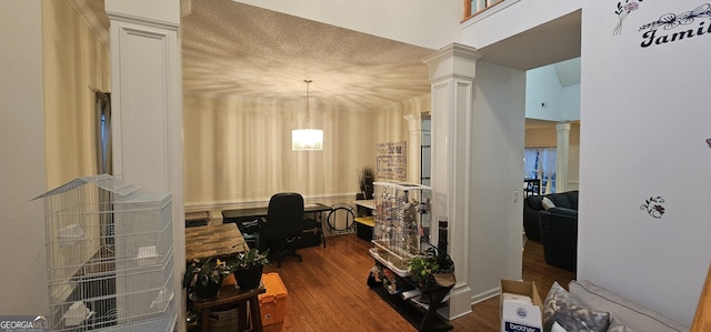 home office with a notable chandelier, ornate columns, and wood finished floors