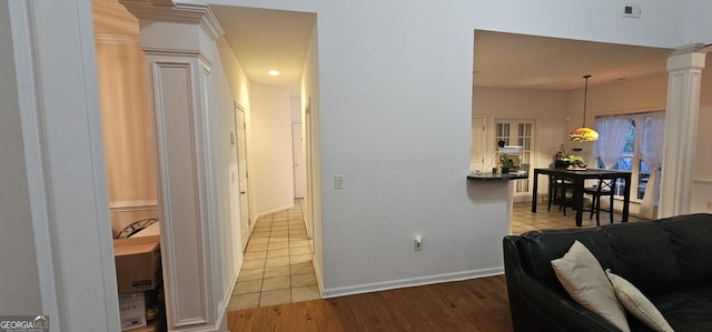 hall with wood finished floors, decorative columns, baseboards, and visible vents