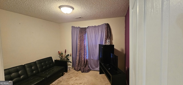 living area with carpet floors, visible vents, and a textured ceiling