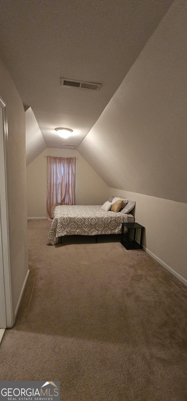 carpeted bedroom featuring visible vents, baseboards, vaulted ceiling, and a textured ceiling
