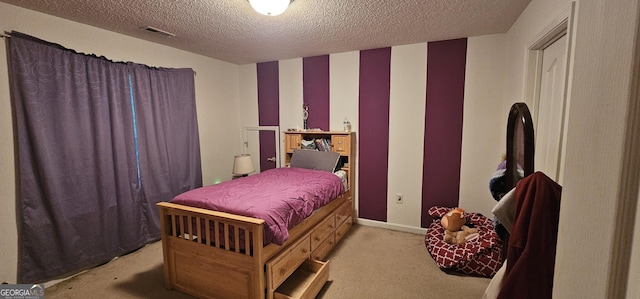 bedroom with a textured ceiling, baseboards, visible vents, and carpet floors