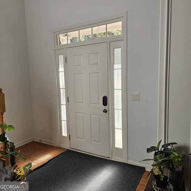 entryway featuring baseboards and wood finished floors