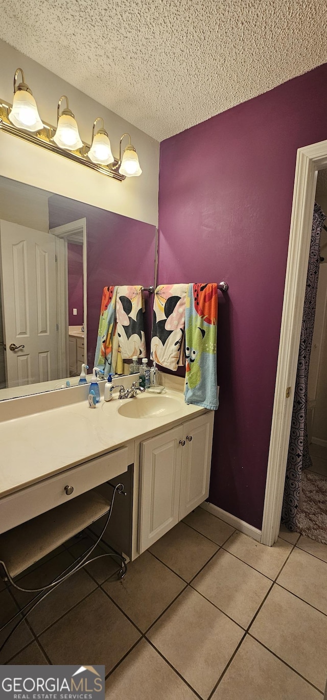 bathroom featuring tile patterned flooring, vanity, and a textured ceiling