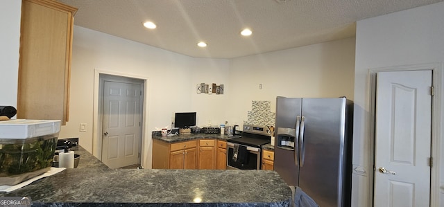 kitchen featuring recessed lighting, a peninsula, a textured ceiling, dark countertops, and appliances with stainless steel finishes