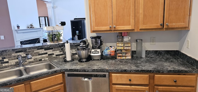 kitchen with a sink, stainless steel dishwasher, dark countertops, and brown cabinets