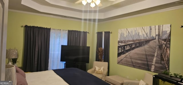 bedroom with ornamental molding and a raised ceiling