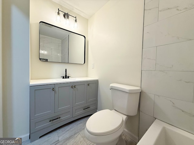 bathroom with vanity, toilet, and baseboards